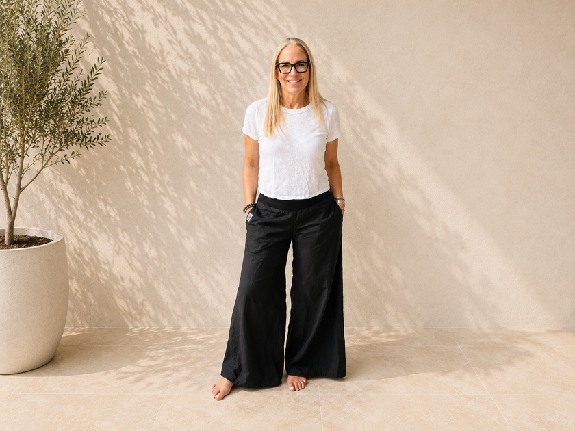 Woman wearing The Presence Pant black wide-leg palazzo pants with side pockets.